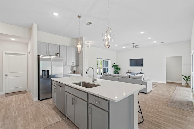kitchen with gray cabinets, visible vents, a sink, light countertops, and stainless steel appliances