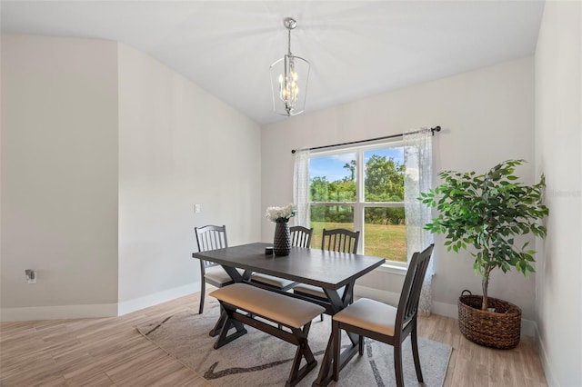 dining area with an inviting chandelier, light wood-style flooring, and baseboards