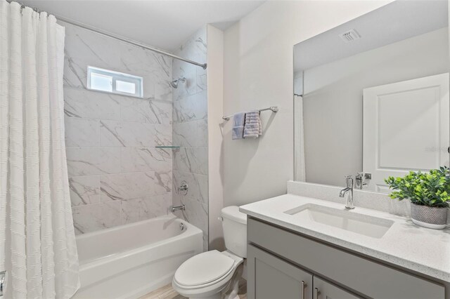 full bathroom featuring vanity, shower / bath combo with shower curtain, toilet, and visible vents
