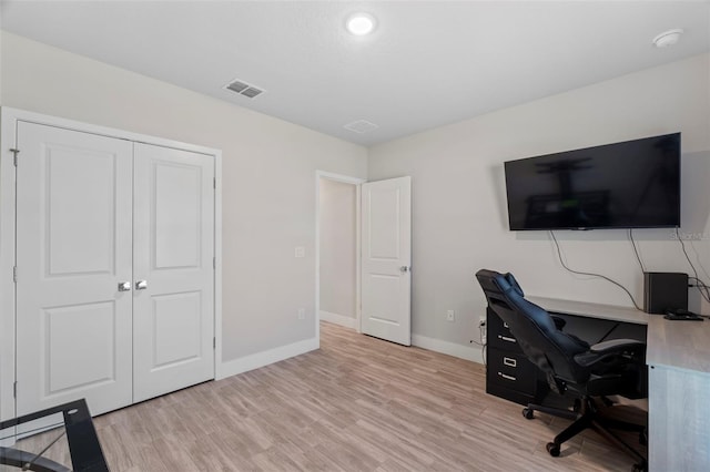 office space featuring baseboards, light wood-style flooring, and visible vents