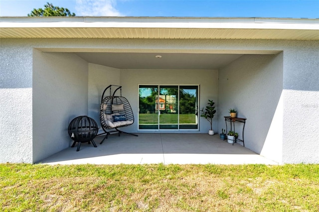 entrance to property featuring a patio area and stucco siding