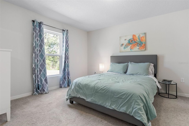 bedroom with baseboards, carpet flooring, and a textured ceiling
