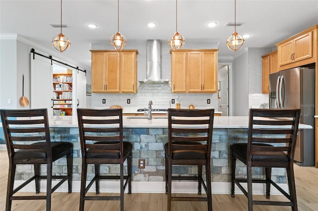 106 Key Grass Ct, Saint Johns, FL 32259 - kitchen with decorative backsplash, stainless steel refrigerator with ice dispenser, light countertops, light brown cabinets, and wall chimney exhaust hood