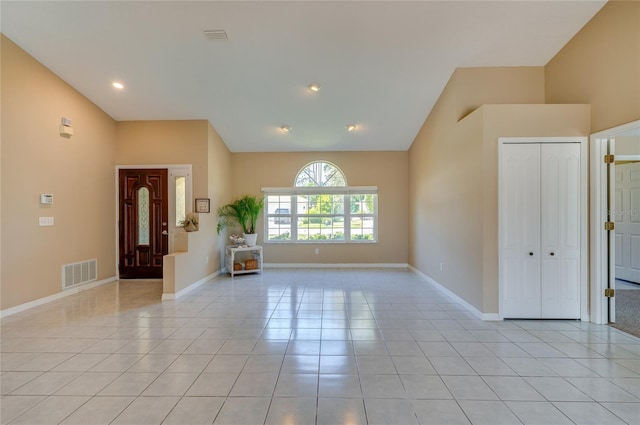 entryway featuring baseboards, visible vents, light tile patterned floors, and vaulted ceiling