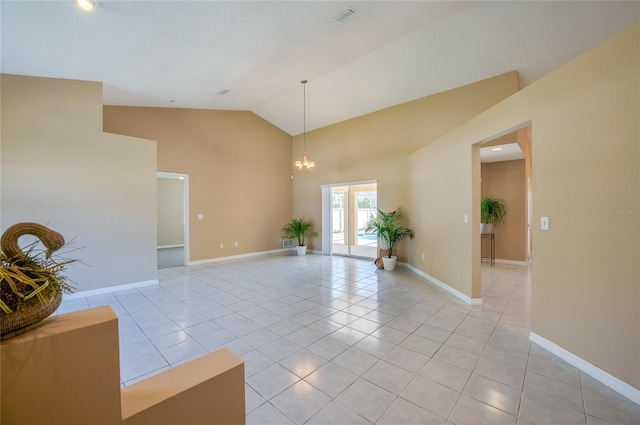 empty room featuring baseboards, light tile patterned floors, and high vaulted ceiling