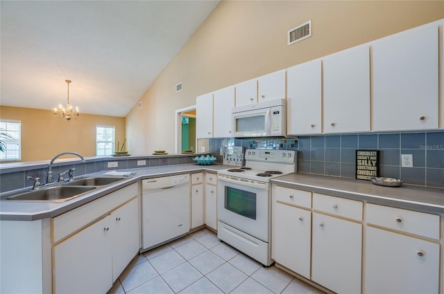 kitchen with visible vents, decorative backsplash, white appliances, a sink, and a notable chandelier