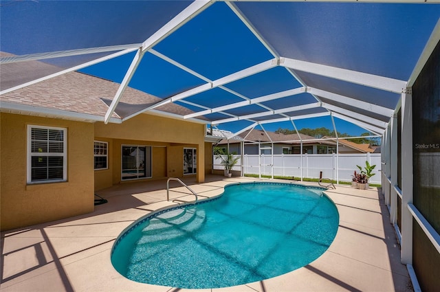 view of pool with a fenced in pool, glass enclosure, a patio area, and fence