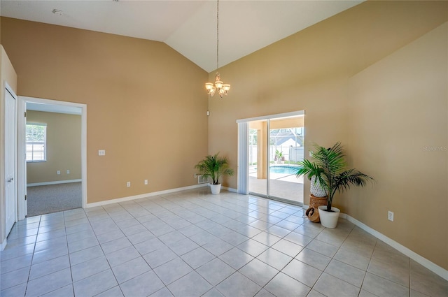 spare room with baseboards, light tile patterned floors, a chandelier, and high vaulted ceiling