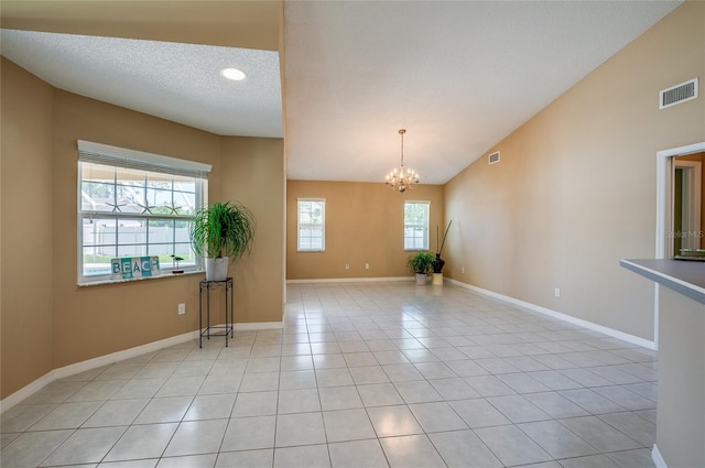 empty room featuring baseboards, a notable chandelier, visible vents, and light tile patterned floors