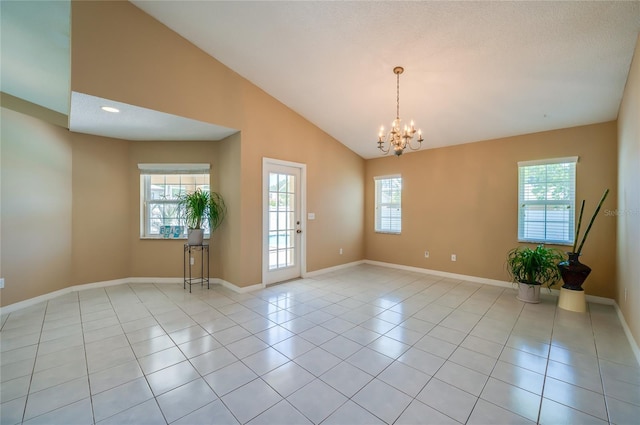 spare room featuring baseboards, a chandelier, light tile patterned floors, and high vaulted ceiling