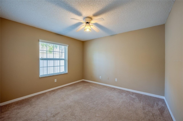 carpeted spare room with baseboards, a textured ceiling, and ceiling fan