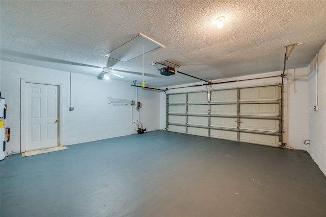 garage featuring concrete block wall, water heater, and a garage door opener