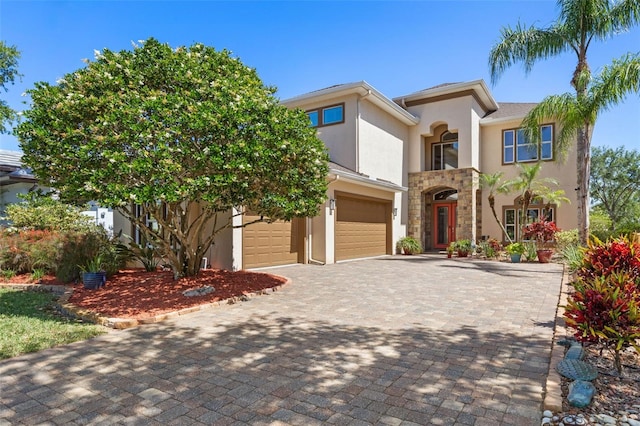 114 Emerald Lake Dr, Palm Coast, FL 32137 - mediterranean / spanish-style home with decorative driveway, a garage, stucco siding, and stone siding