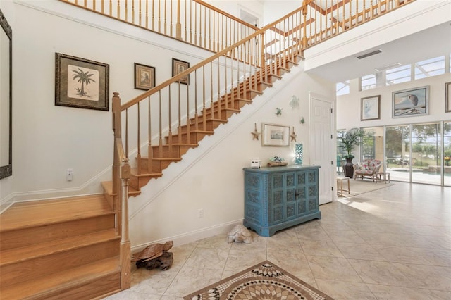 114 Emerald Lake Dr, Palm Coast, FL 32137 - stairs featuring baseboards, a high ceiling, and visible vents