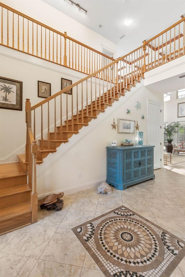 114 Emerald Lake Dr, Palm Coast, FL 32137 - staircase with baseboards, marble finish floor, and a high ceiling