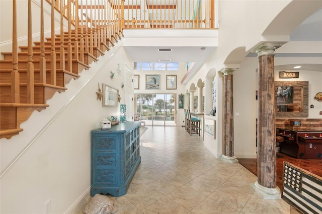 114 Emerald Lake Dr, Palm Coast, FL 32137 - tiled entryway with decorative columns, visible vents, stairway, baseboards, and a high ceiling