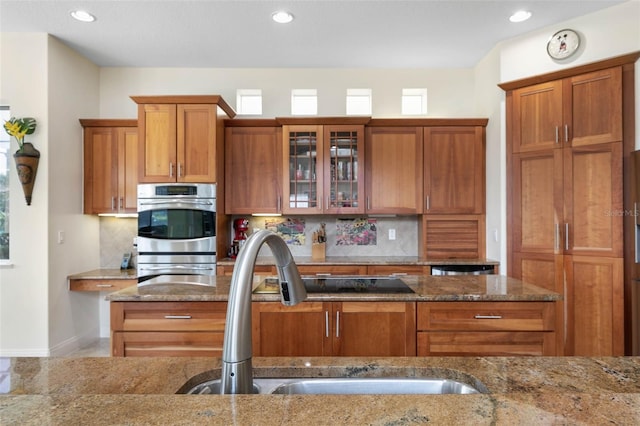 114 Emerald Lake Dr, Palm Coast, FL 32137 - kitchen with brown cabinets, stone counters, and a sink
