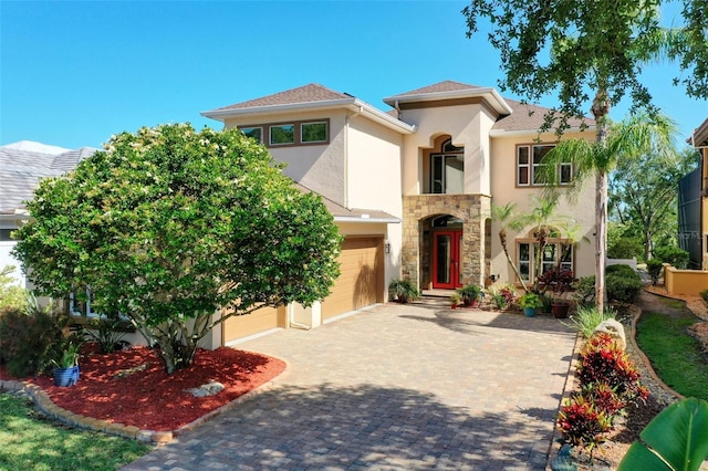 114 Emerald Lake Dr, Palm Coast, FL 32137 - mediterranean / spanish-style house with decorative driveway, a garage, stone siding, and stucco siding