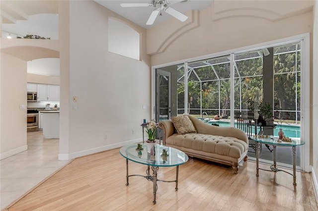 69 Coquina Ridge Way, Ormond Beach, FL 32174 - living area featuring a sunroom, ceiling fan, a healthy amount of sunlight, and a towering ceiling