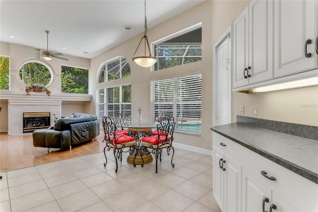 69 Coquina Ridge Way, Ormond Beach, FL 32174 - dining room with a tiled fireplace, baseboards, ceiling fan, and light tile patterned floors