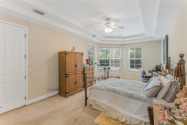 69 Coquina Ridge Way, Ormond Beach, FL 32174 - bedroom with ceiling fan, light carpet, baseboards, a tray ceiling, and visible vents