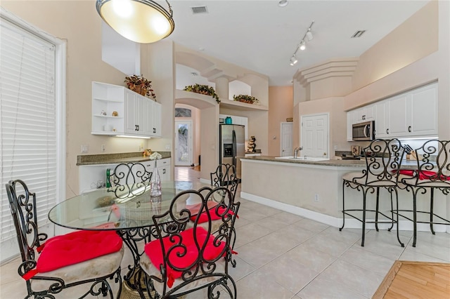 69 Coquina Ridge Way, Ormond Beach, FL 32174 - dining room with light tile patterned flooring, arched walkways, and visible vents
