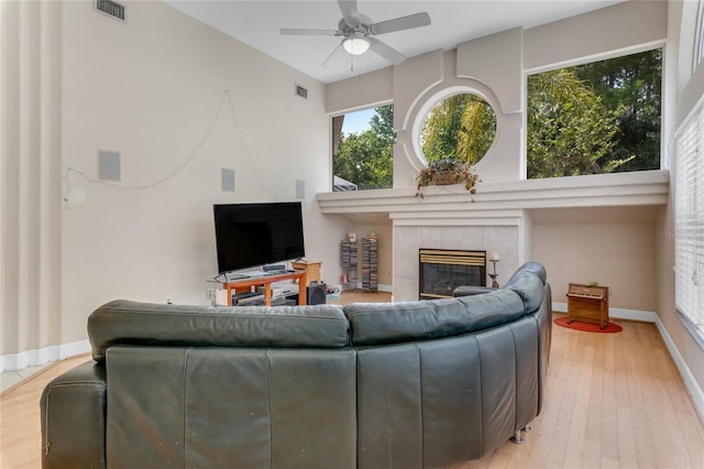 69 Coquina Ridge Way, Ormond Beach, FL 32174 - living room with ceiling fan, visible vents, a tiled fireplace, and wood finished floors