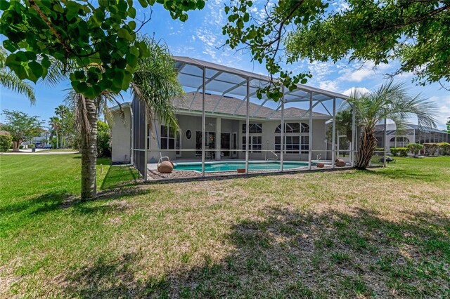 69 Coquina Ridge Way, Ormond Beach, FL 32174 - back of house featuring a lanai, stucco siding, a yard, and an outdoor pool