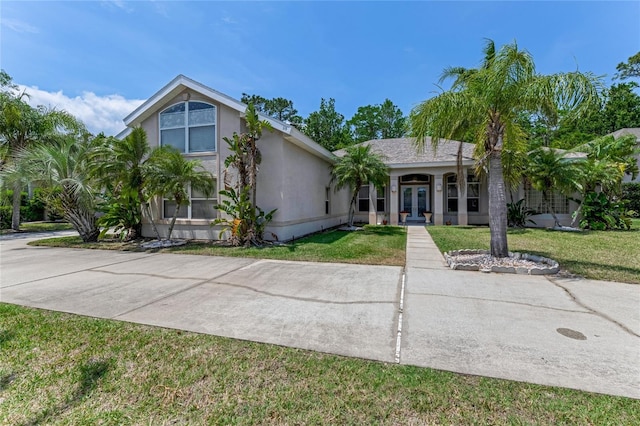 69 Coquina Ridge Way, Ormond Beach, FL 32174 - view of front of property with french doors, stucco siding, and a front yard