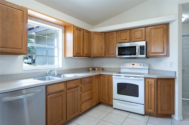 28 Weller Ln, Palm Coast, FL 32164 - kitchen featuring brown cabinetry, a sink, light countertops, lofted ceiling, and stainless steel appliances