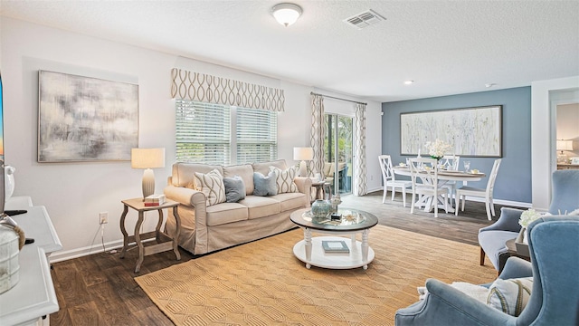 living room with visible vents, wood finished floors, baseboards, recessed lighting, and a textured ceiling