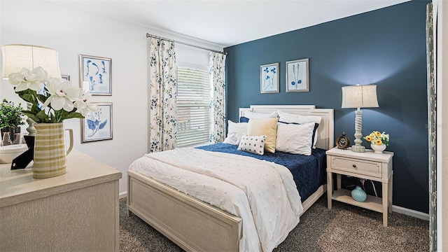 bedroom with baseboards and dark carpet