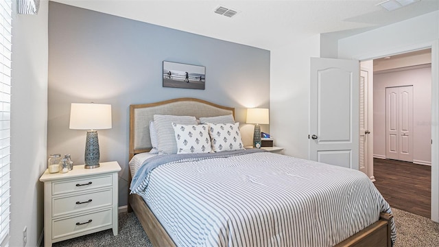 bedroom featuring visible vents and dark wood finished floors