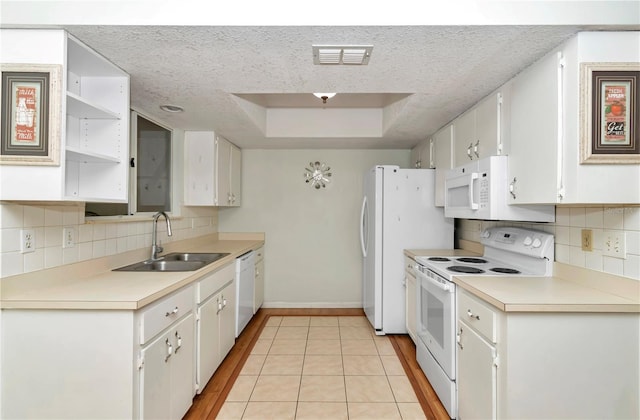 8720 SW 108th Ln, Ocala, FL 34481 - kitchen featuring a sink, white appliances, white cabinetry, baseboards, and a tray ceiling
