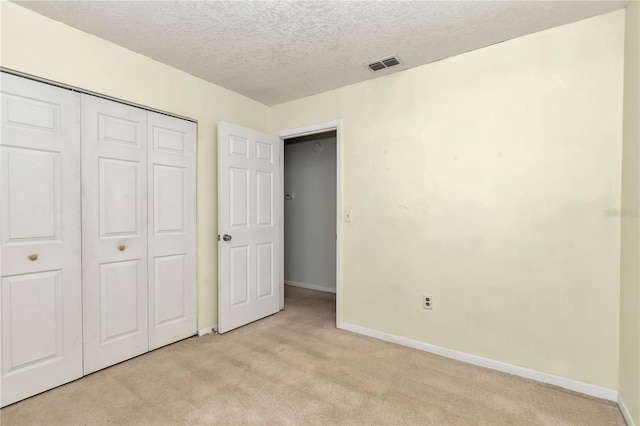 8720 SW 108th Ln, Ocala, FL 34481 - unfurnished bedroom with light carpet, a textured ceiling, baseboards, visible vents, and a closet