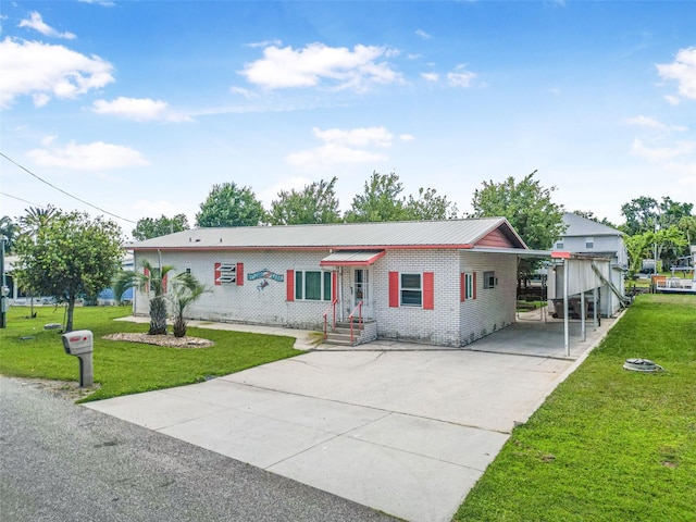 view of front of house featuring brick siding, a carport, a front lawn, and concrete driveway