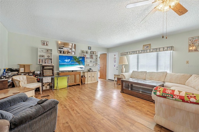 living room with a textured ceiling, ceiling fan, and wood finished floors