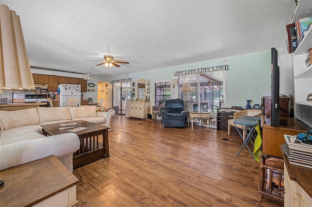 living room with a ceiling fan, a textured ceiling, and wood finished floors