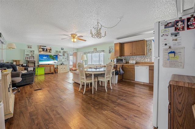 dining space featuring a ceiling fan, dark wood-style flooring, and a textured ceiling