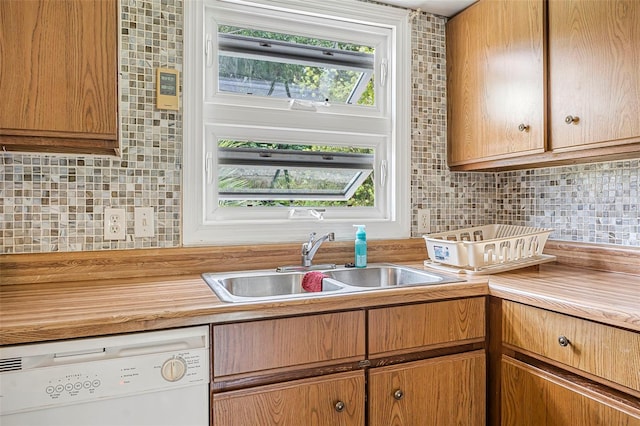 kitchen featuring a sink, backsplash, and dishwasher