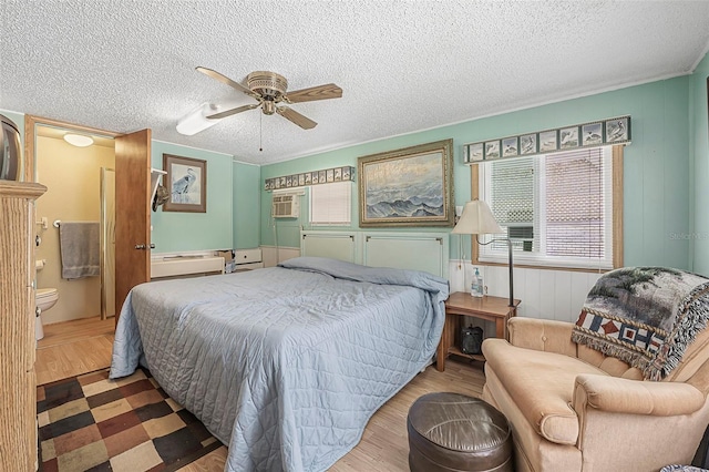bedroom featuring a textured ceiling, ceiling fan, wood finished floors, and connected bathroom