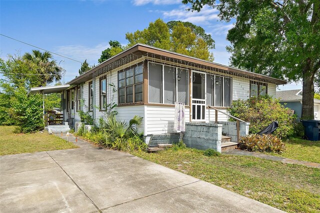 bungalow with a sunroom and a front lawn