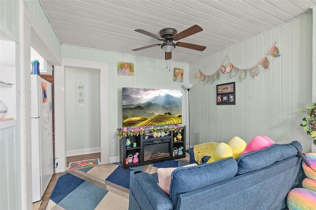living area featuring ceiling fan, wood finished floors, and wooden ceiling
