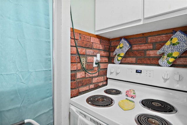 interior details featuring electric stove and white cabinets