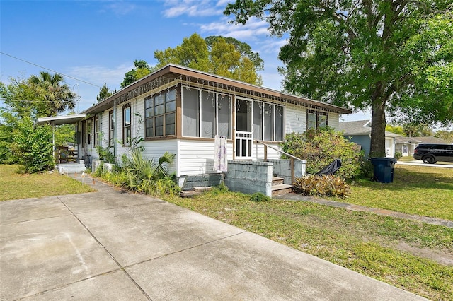 view of front of home featuring a sunroom and a front yard