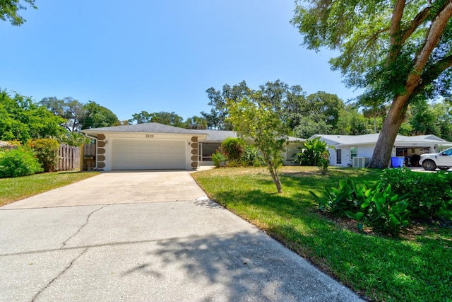 single story home featuring a garage, central air condition unit, fence, a front lawn, and concrete driveway