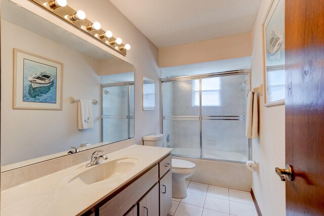 bathroom with toilet, tile patterned flooring, bath / shower combo with glass door, and vanity