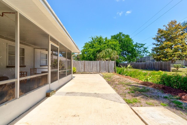 view of patio / terrace featuring a sunroom and fence