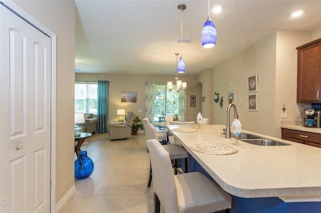 35 Park Place Cir, Palm Coast, FL 32164 - kitchen with hanging light fixtures, a sink, light tile patterned floors, open floor plan, and a breakfast bar