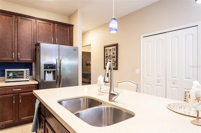 35 Park Place Cir, Palm Coast, FL 32164 - kitchen with dark brown cabinetry, hanging light fixtures, stainless steel fridge, a sink, and a toaster
